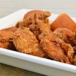 crispy buttermilk fried chicken with a side of dinner roll on a serving dish