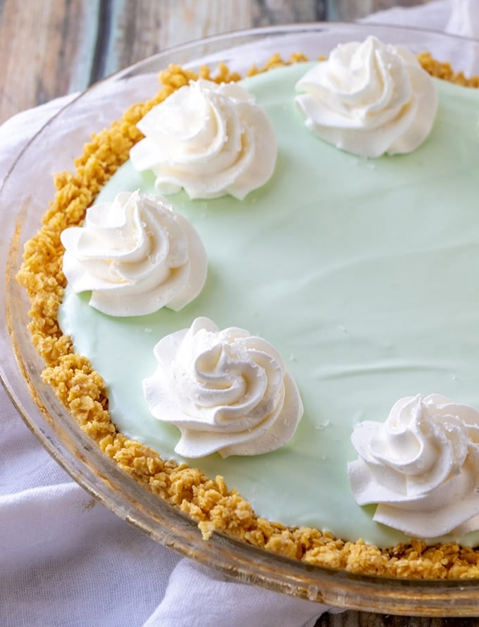 Frozen Margarita Pie with whipped cream in a clear pie plate