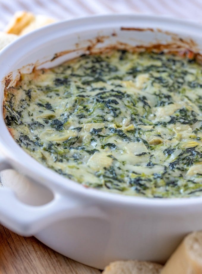 Cheesy Spinach and Artichoke Dip in a white baking dish