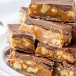 chocolate caramel candy bars stacked on a white plate