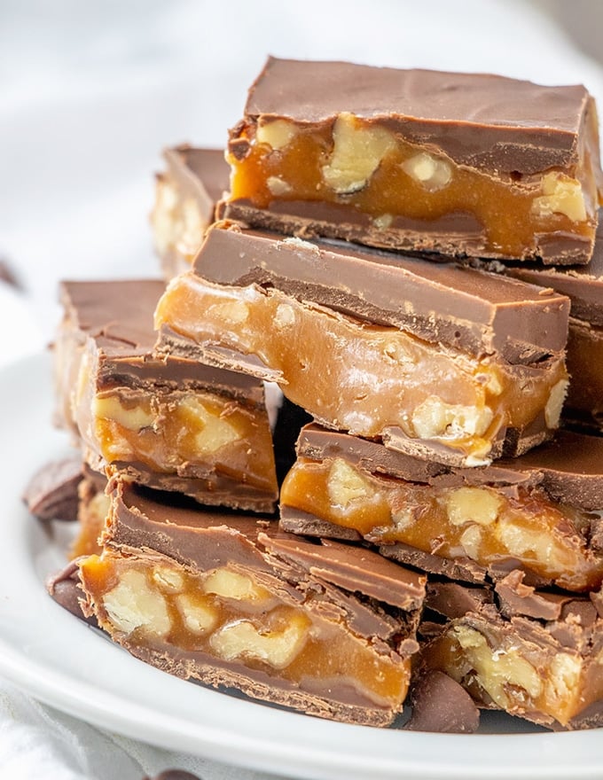 chocolate caramel candy bars stacked on a white plate