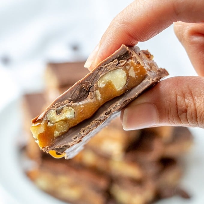 holding chocolate caramel candies with fingers