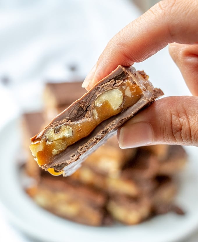 holding chocolate caramel candies with fingers