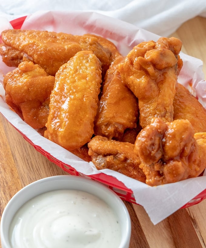  Buffalo Chicken Wings on red basket with a side of ranch dressing