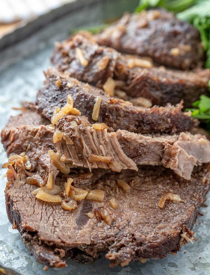 sliced beef roast in foil on a serving platter