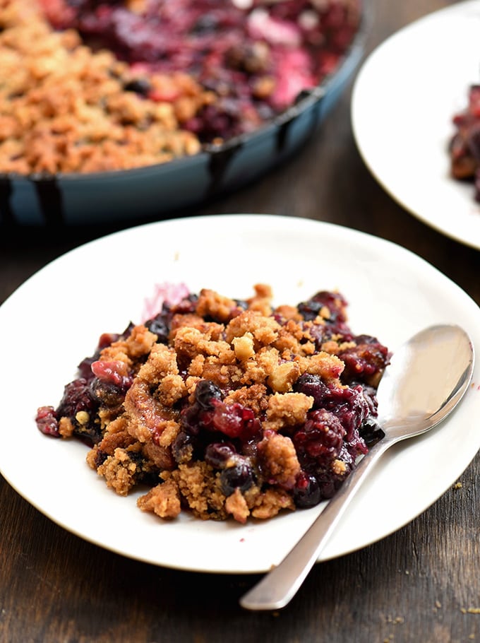 Berry crumble on a white plate with buttery crumble