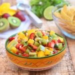 kiwi, mango and strawberry salsa in a serving bowl with a side of corn chips