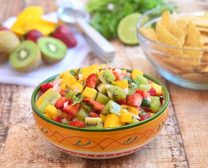 kiwi, mango and strawberry salsa in a serving bowl with a side of corn chips