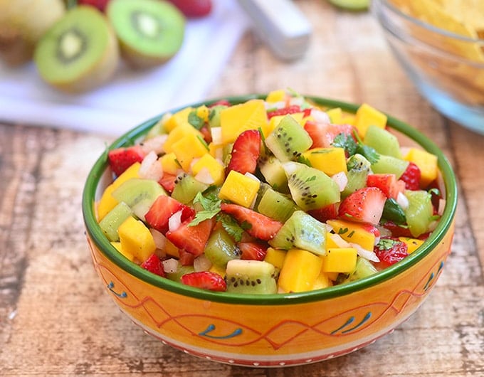 mango salsa with kiwi and strawberries in a serving bowl