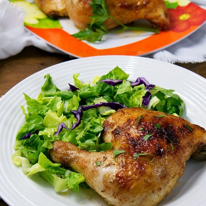 Brined Roasted Chicken on a serving plate with green salad