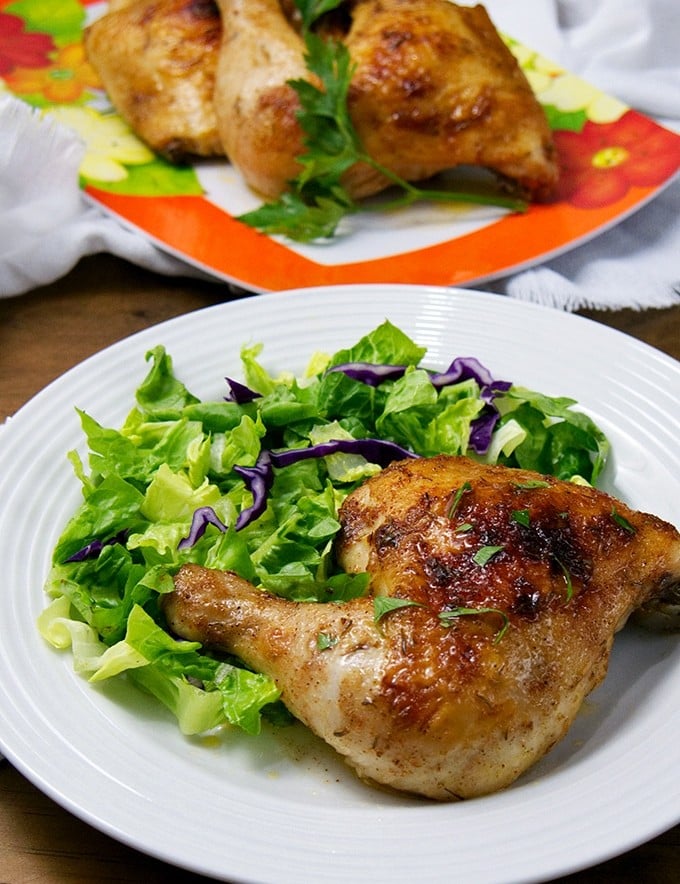 Brined Roasted Chicken on a serving plate with green salad