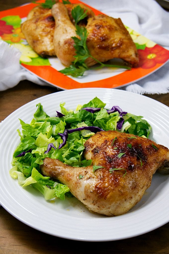 Brined Roasted Chicken on a serving plate with green salad