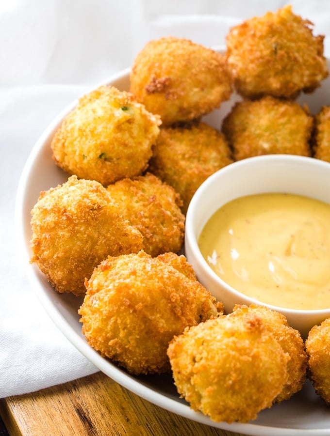 fried potato balls in a serving plate with dipping sauce 