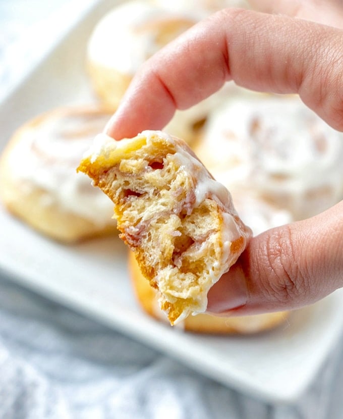 holding cut cream cheese danish with fingers