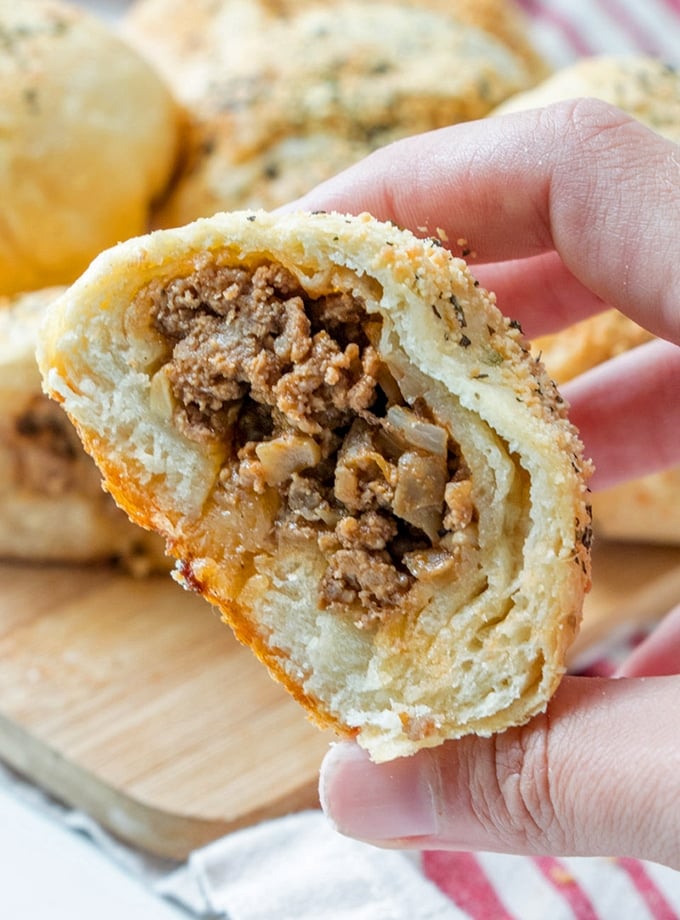 holding cut sloppy joe bread roll with hand