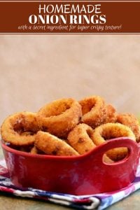 crispy onion rings in a ceramic container with a side of dipping sauce