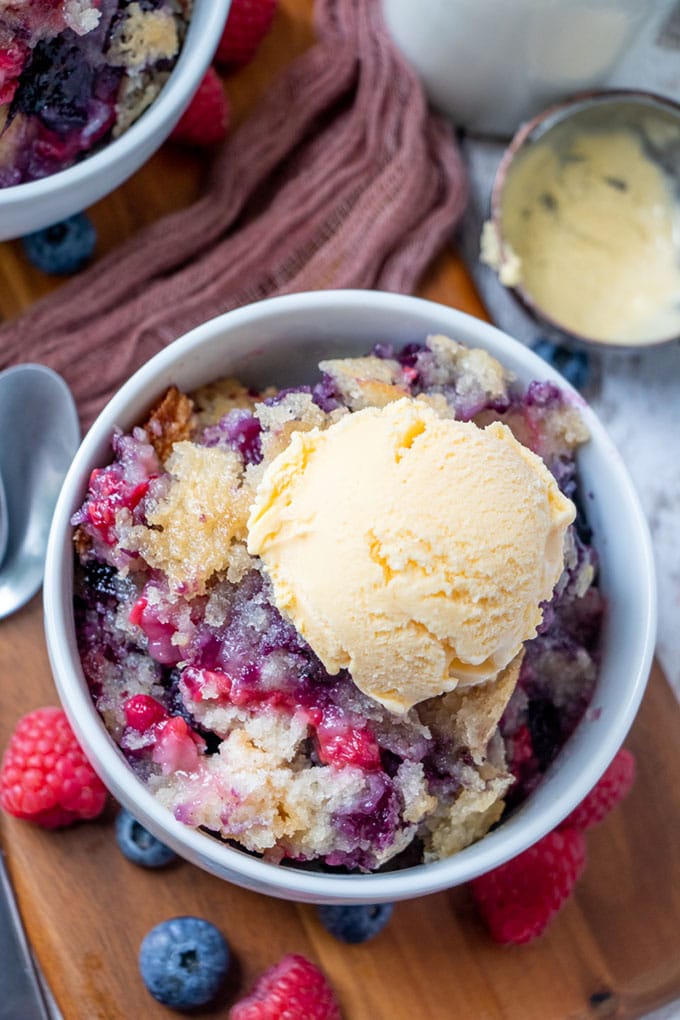 Mixed Berry Cobbler in a bowl with vanilla ice cream