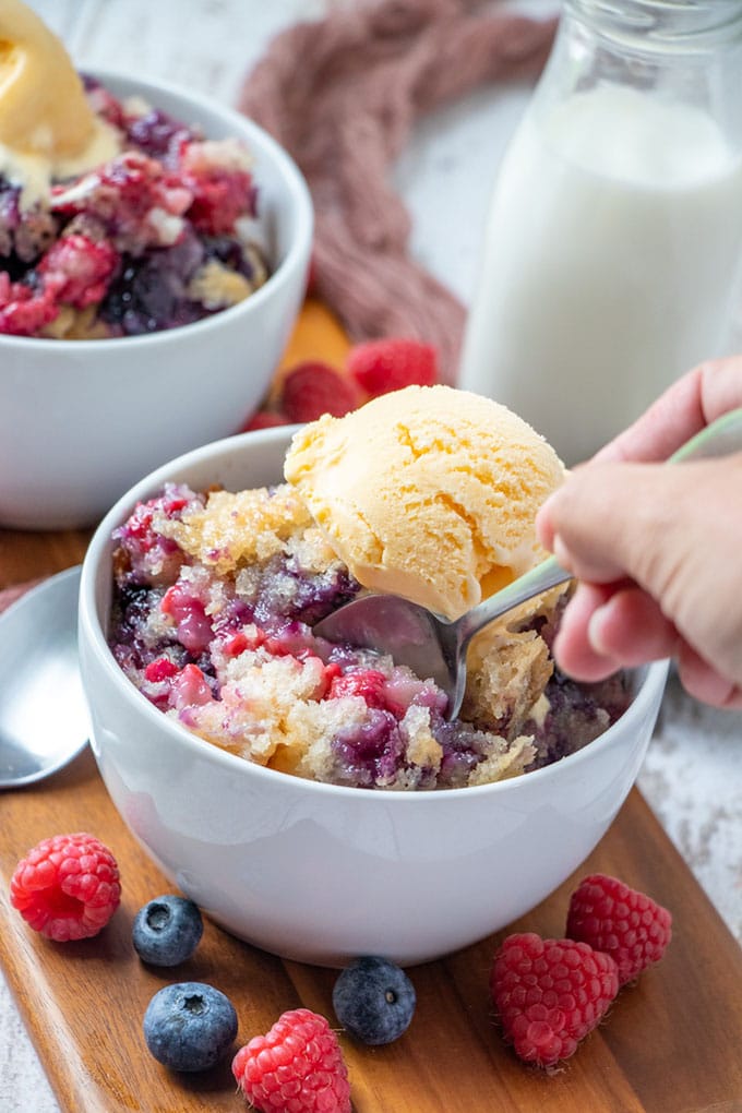 eating fruit cobbler with a spoon in a bowl