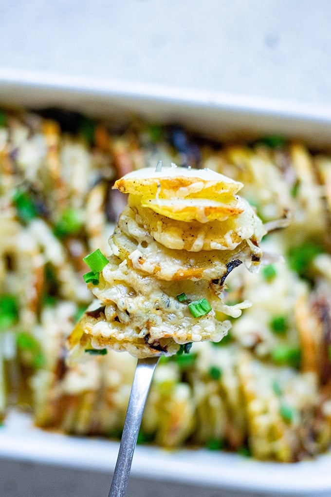 serving roasted sliced potatoes from a baking dish with a fork