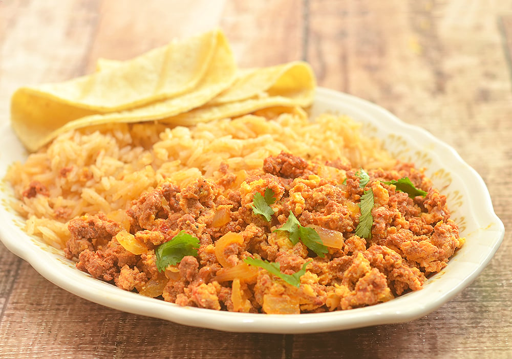 Chorizo con Huevos made with crumbled Mexican sausage and scrambled eggs. Hearty and delicious, it's perfect paired with Spanish rice and beans for breakfast as well as fillings for tacos, enchiladas or burritos.