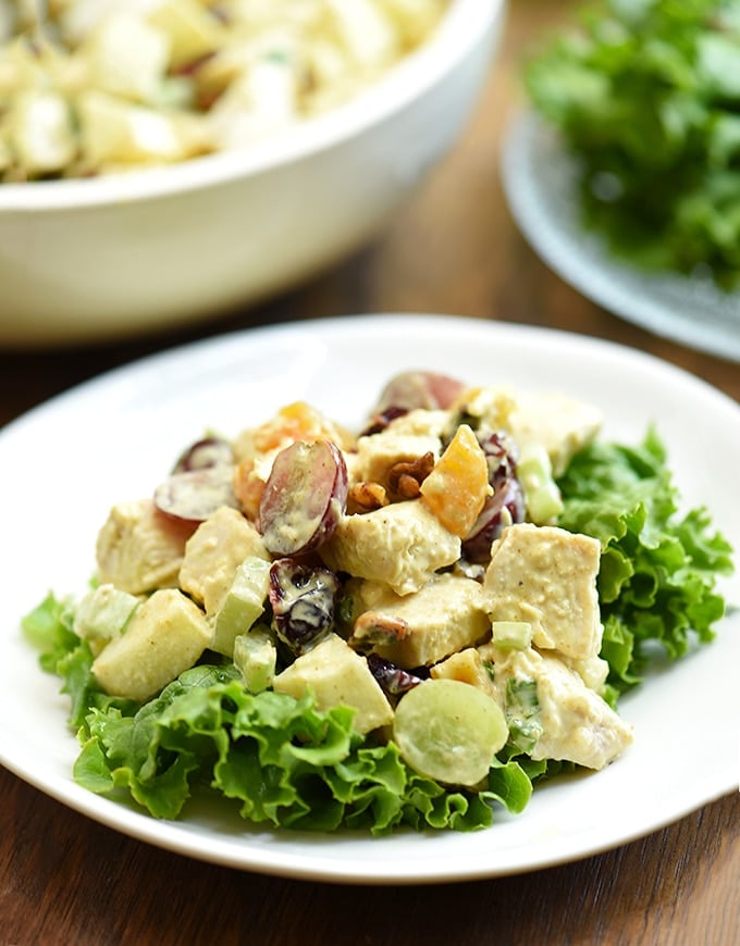 curry chicken salad with grapes, apples, dried fruit on lettuce leaves