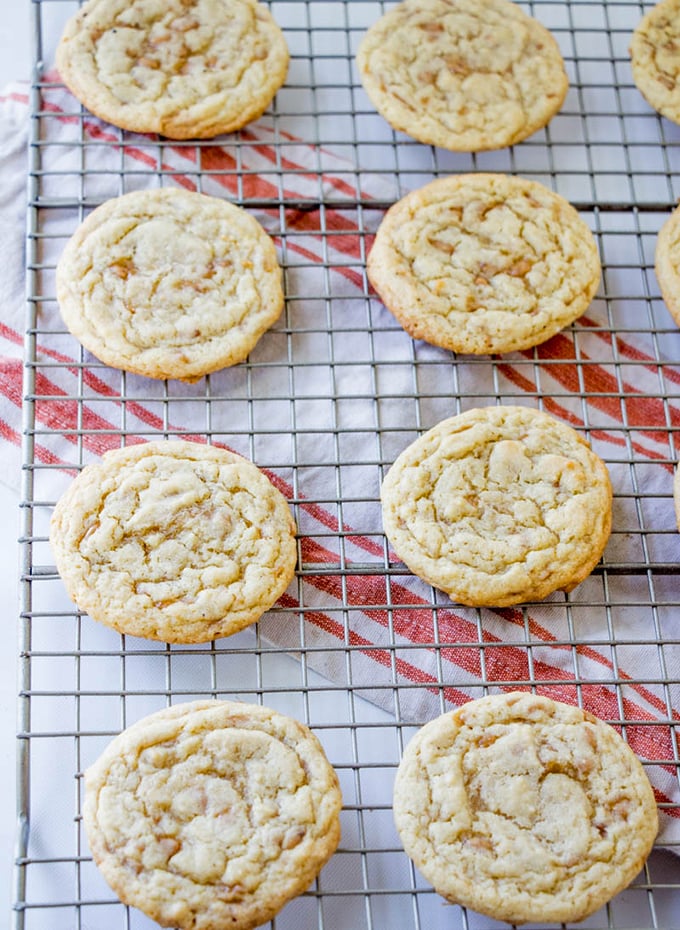 Yummy toffee drop cookies cooling on a wire rack before they're served with a tall glass of milk. 