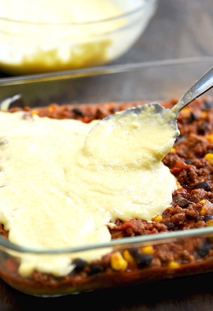 Spreading cornbread topping on tamale pie beef filling before baking up this yummy casserole. 