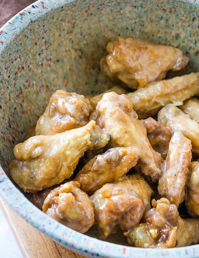 breaded chicken wings tossed in caramel sauce in a bowl