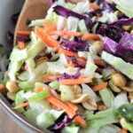 Wood Ranch BBQ and Grill copycat peanut coleslaw in bowl with a wooden spoon for serving.