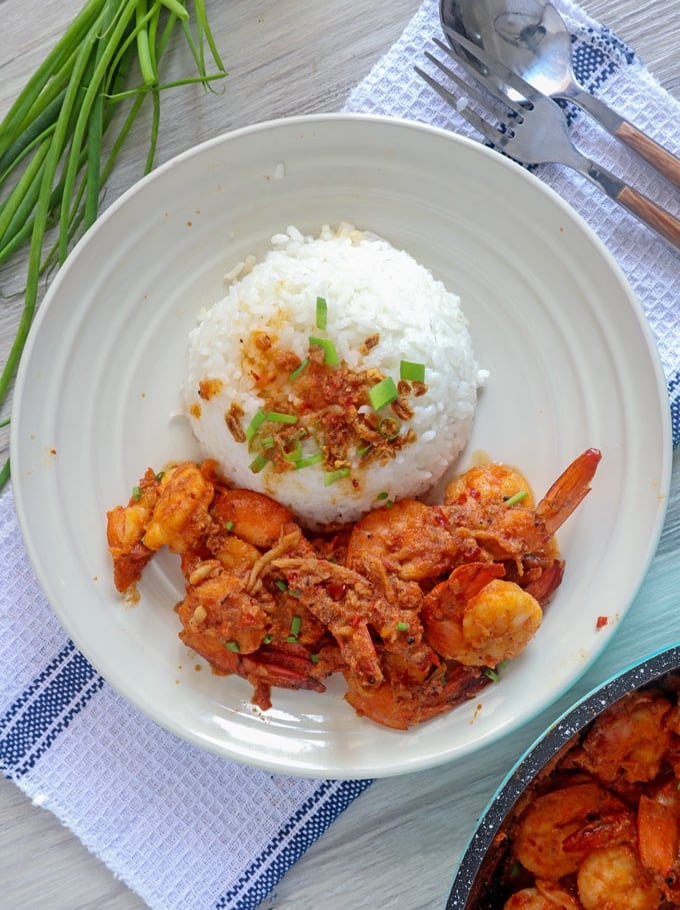 spicy shrimp in chili garlic sauce with rice on a white plate