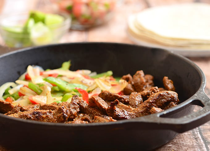 Skillet Beef Fajitas with sirloin, bell peppers, and onions marinated in lime and seasonings and seared to tender perfection. Serve with warm tortillas and your favorite fixings for an amazing Mexican feast!