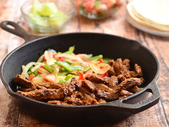 Skillet Beef Fajitas with sirloin, bell peppers, and onions marinated in lime and seasonings and seared to tender perfection. Serve with warm tortillas and your favorite fixings for an amazing Mexican feast!