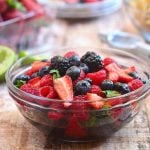 berry salsa with blueberries, blackeberries, strawberries and raspberries in a clear serving bowl with a side of tortilla chips