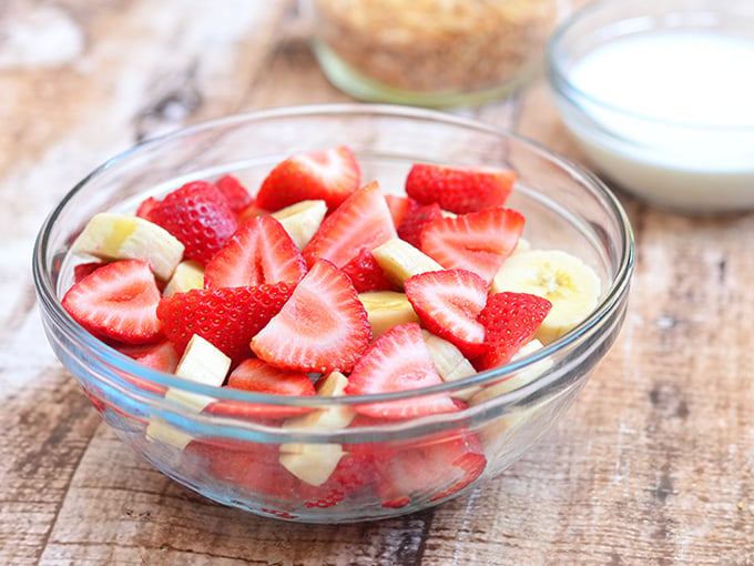 Strawberry Banana and Cream Salad with strawberries. bananas, sour cream dressing, and toasted coconut. Sweet and creamy, it's a healthy and delicious addition to any summer potluck!