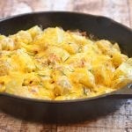 Cheesy Skillet Potatoes is the ultimate potato side dish! With fluffy Yukon gold potatoes, creamy sour cream sauce, crisp bacon, gooey cheese, and fresh rosemary, it's hearty, delicious and a guaranteed family favorite.