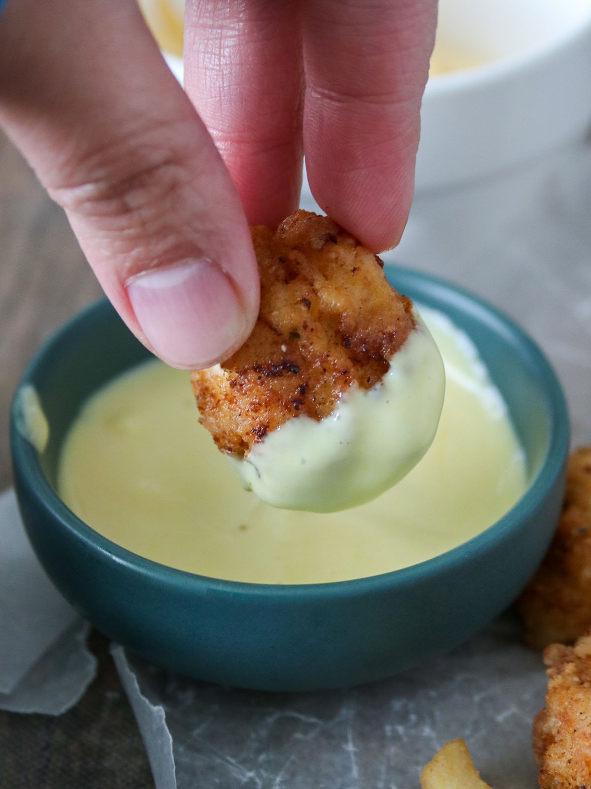 dipping Crispy Popcorn Chicken in honey mustard sauce