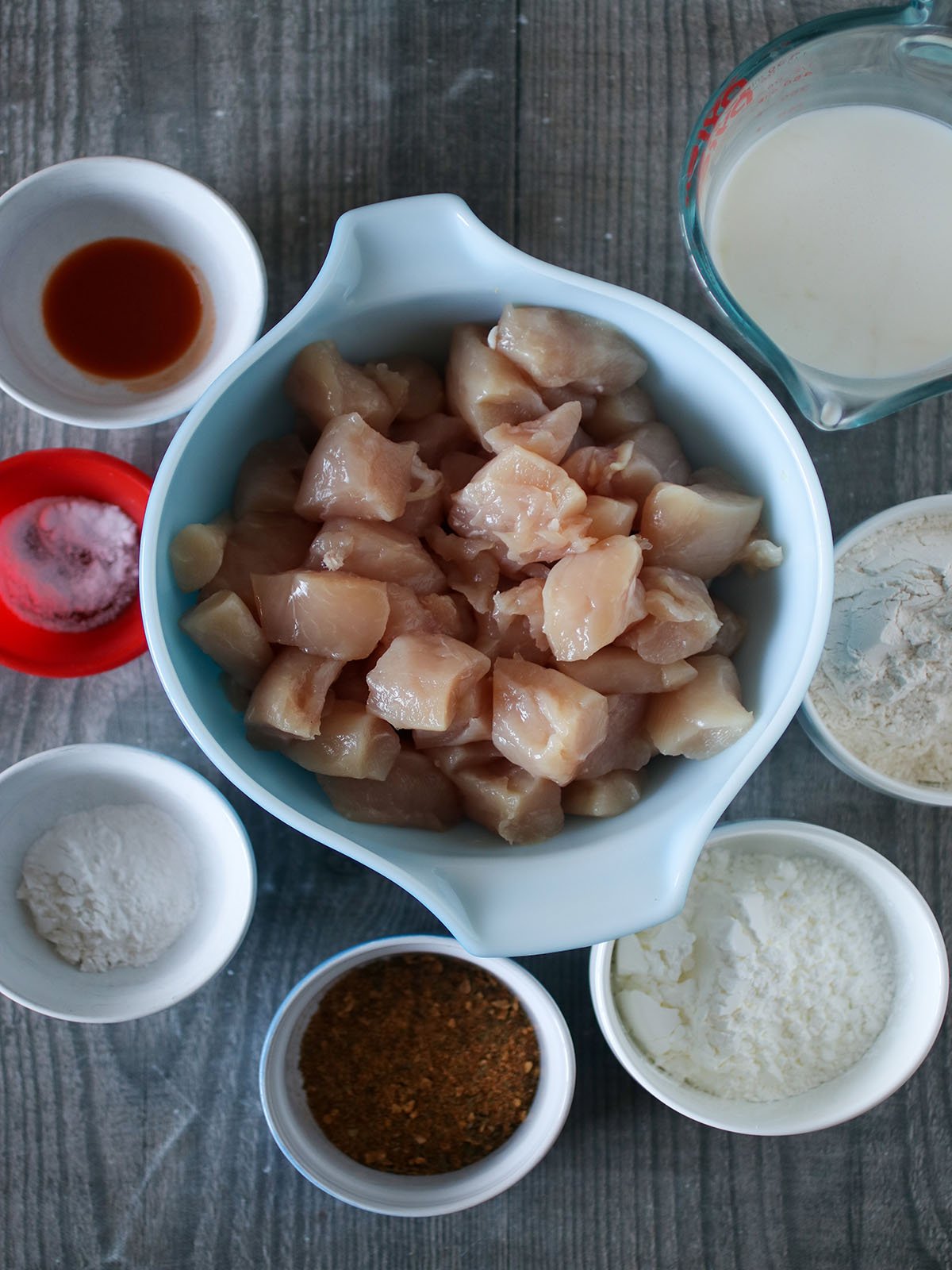 chicken cubes, flour, cornstarch, baking powder, Cajun seasoning, buttermilk, salt, pepper in bowls