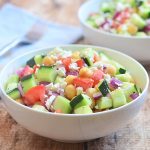 Cucumber Tomato and Feta Salad with crisp cucumbers, tomatoes, garbanzo beans, and red onions tossed in a tangy red wine vinaigrette. Chock-full of amazing texture and flavor, it's sure to be a hit with the crowd!