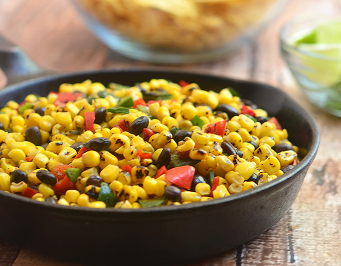 Roasted Corn and Black Bean Salad bursting with the smoky flavors of grilled corn, poblano peppers; and black beans. Delicious as a dip for tortilla chips yet just as awesome as a vegetarian filling for enchiladas or quesadillas.