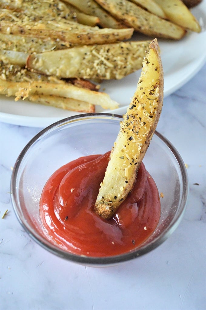 dipping parmesan potato wedges in ketchup