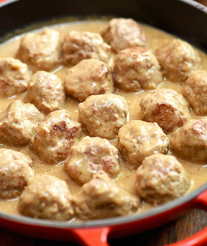 homemade Swedish meatballs with cream sauce in a red skillet