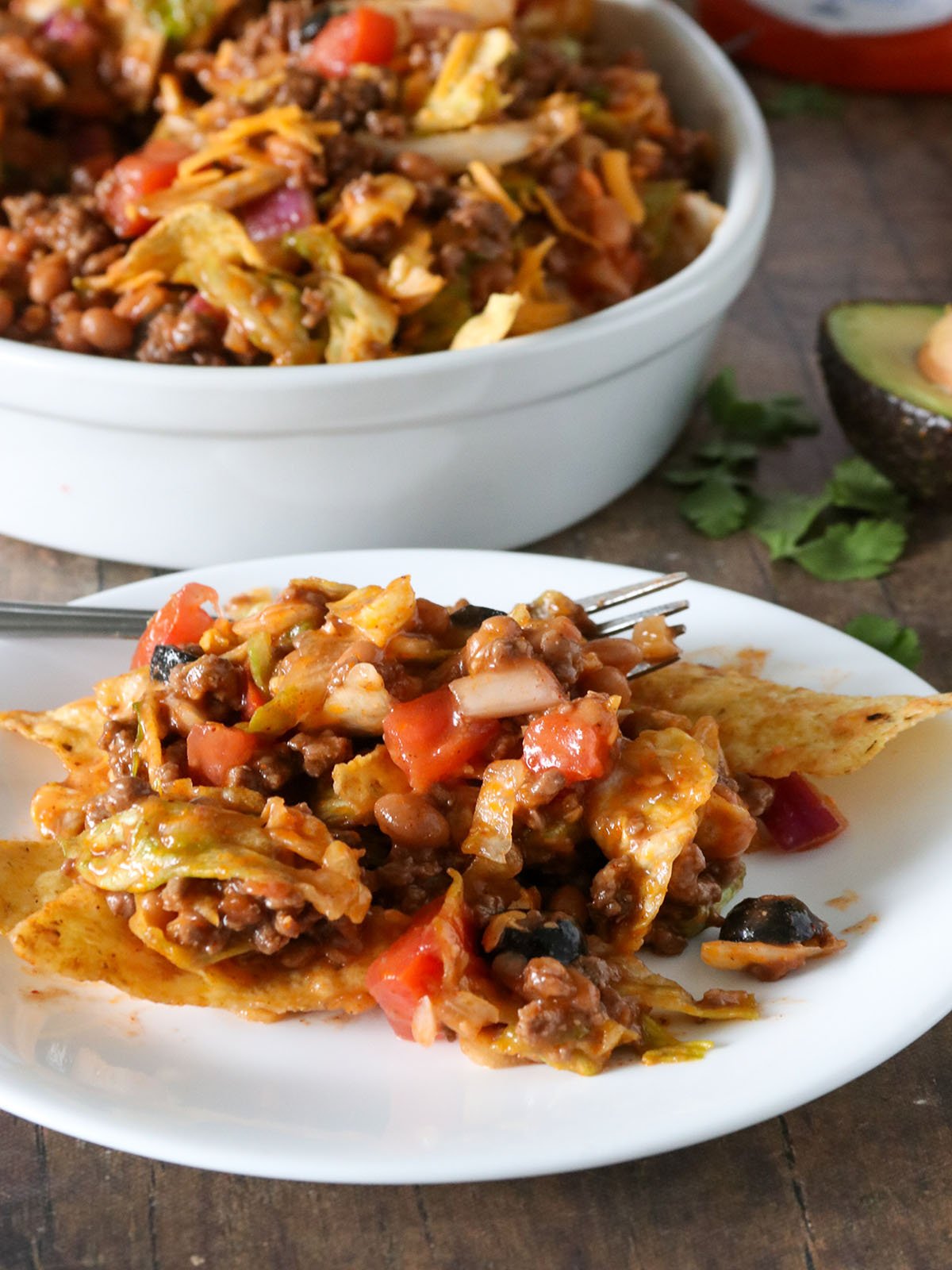 taco salad with corn chips on a white serving plate