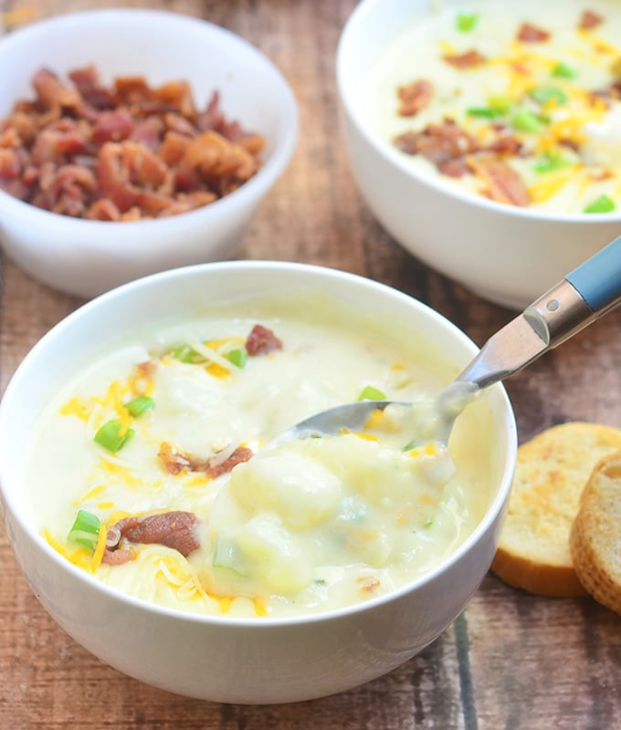 Ultimate Baked Potato Soup loaded with potato chunks, bacon bits, green onions, shredded cheese, and sour cream plus a thick, creamy broth you'd want to dive into! Hearty and delicious, it's the ultimate comfort food!