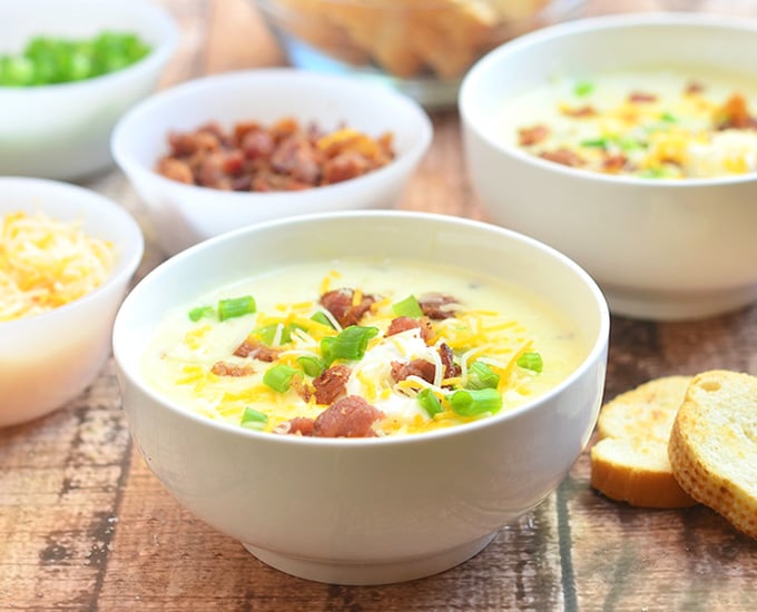 Ultimate Baked Potato Soup loaded with potato chunks, bacon bits, green onions, shredded cheese, and sour cream plus a thick, creamy broth you'd want to dive into! Hearty and delicious, it's the ultimate comfort food!