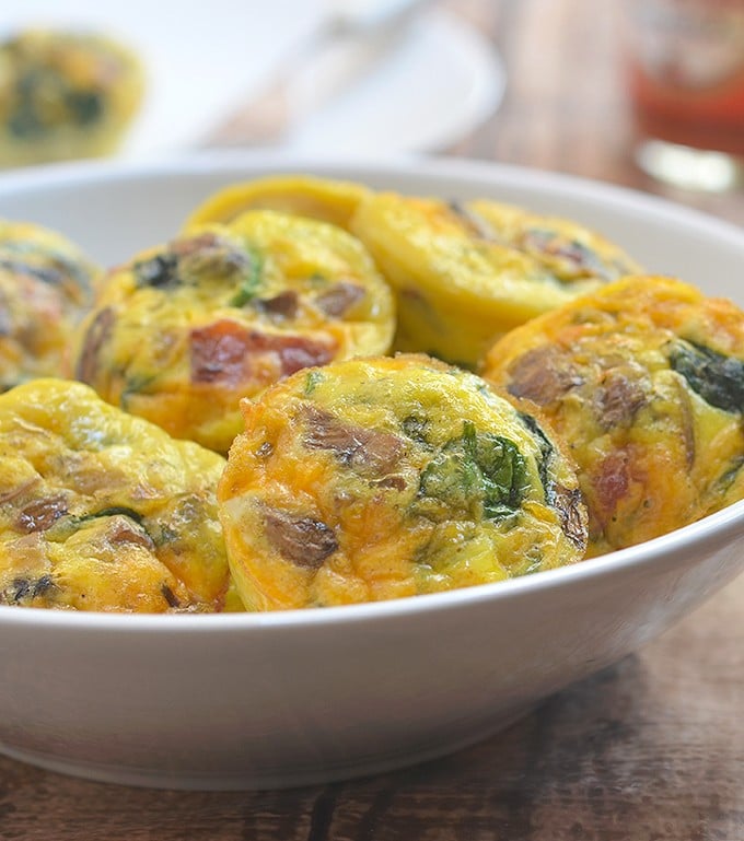 Bacon Spinach and Mushroom Egg Muffins loaded with crisp bacon, meaty mushrooms, and baby spinach. An excellent source of protein and full of healthy veggies, these portable mini frittatas are nutritious as they are delicious!