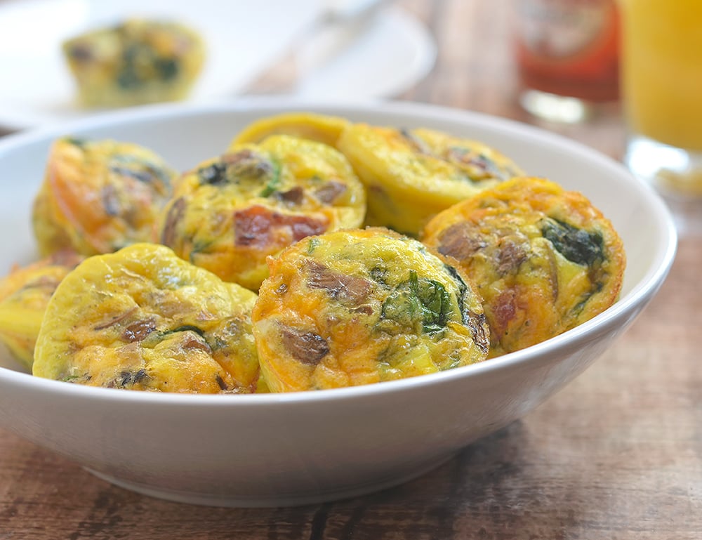 Bacon Spinach and Mushroom Egg Muffins loaded with crisp bacon, meaty mushrooms, and baby spinach. An excellent source of protein and full of healthy veggies, these portable mini frittatas are nutritious as they are delicious!