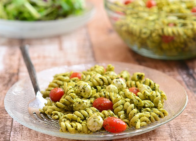 Pesto Pasta Salad with al dente pasta, bocconcini, and juicy cherry tomatoes tossed in a rich pesto sauce--a perfect summer lunch for one or a crowd!