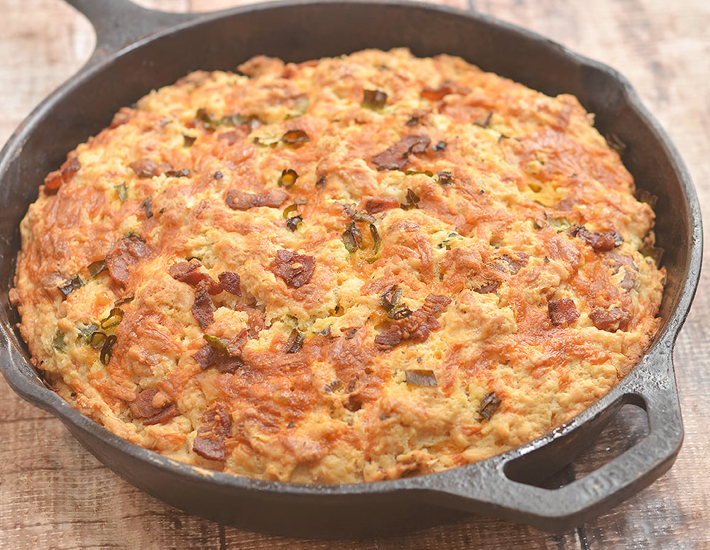 Skillet Cheddar-Bacon Beer Bread is a savory quick bread with smoky bacon, sharp cheddar, and green onions. Golden and crisp on the outside and moist and fluffy on the inside, it's the perfect pair to your favorite hearty soup or homemade chili.