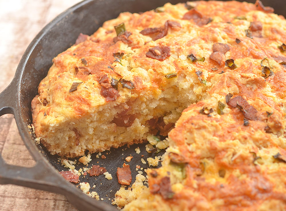 Skillet Cheddar-Bacon Beer Bread is a savory quick bread with smoky bacon, sharp cheddar, and green onions. Golden and crisp on the outside and moist and fluffy on the inside, it's the perfect pair to your favorite hearty soup or homemade chili.