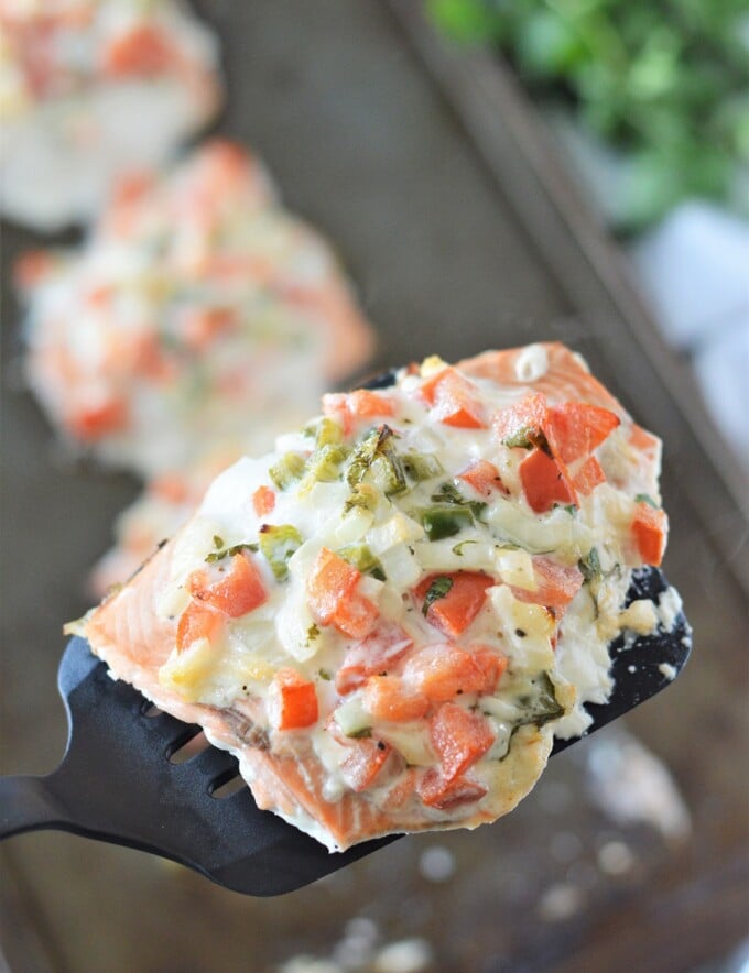 serving baked salmon with a spatula from a baking sheet.